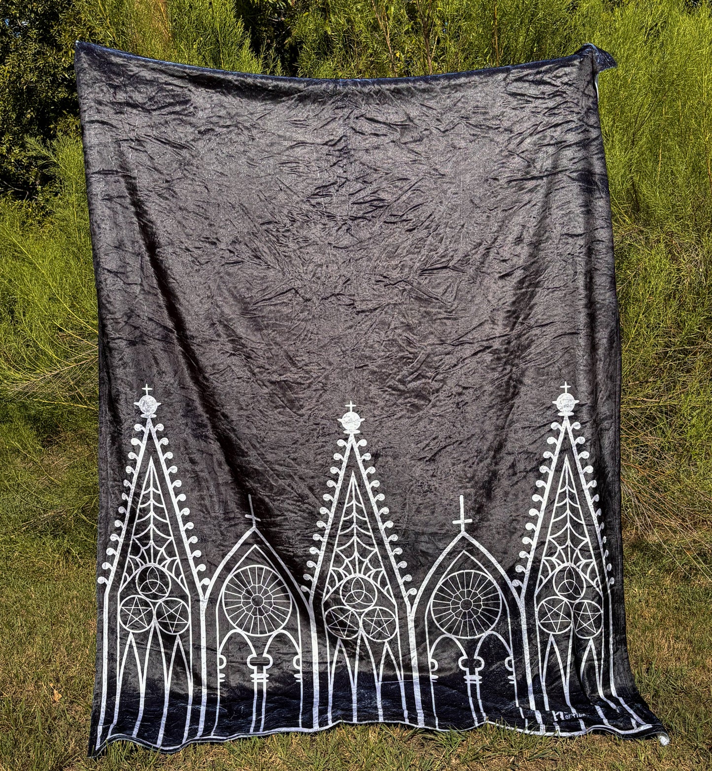 A black blanket featuring designs of Gothic gables in white.