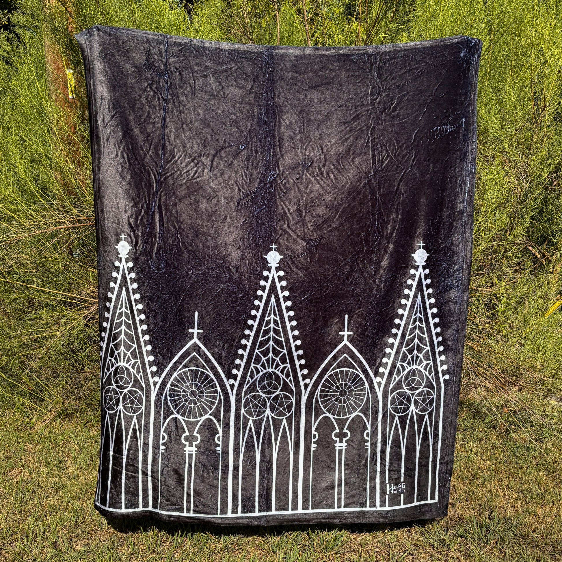 A black blanket featuring designs of Gothic gables in white.