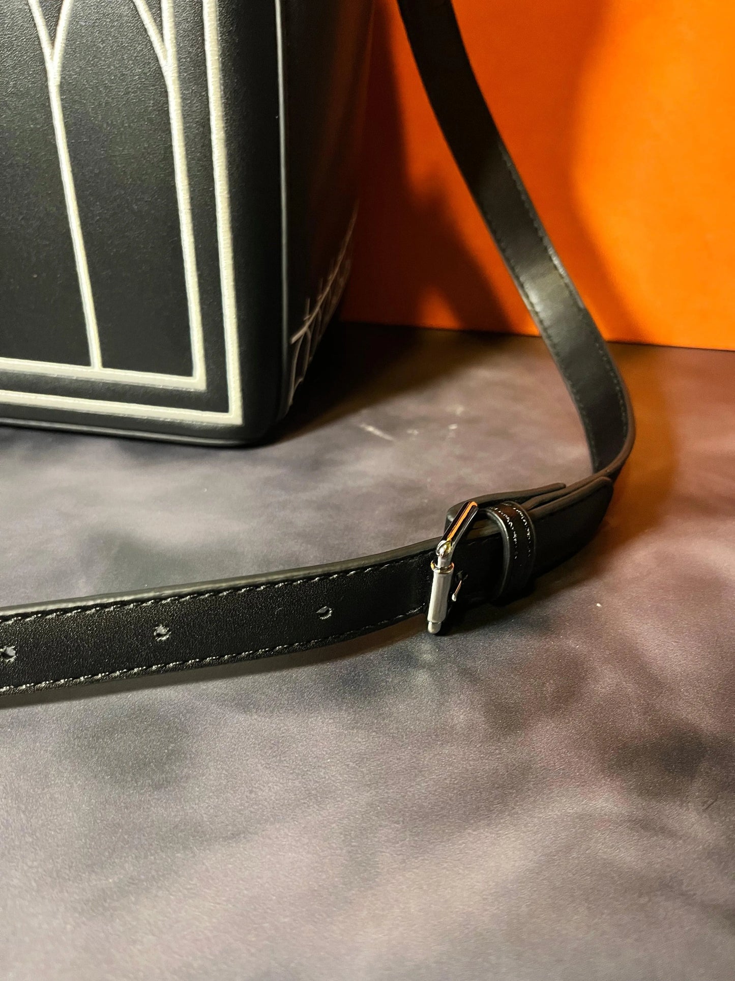 Close up of a long black strap for a purse.