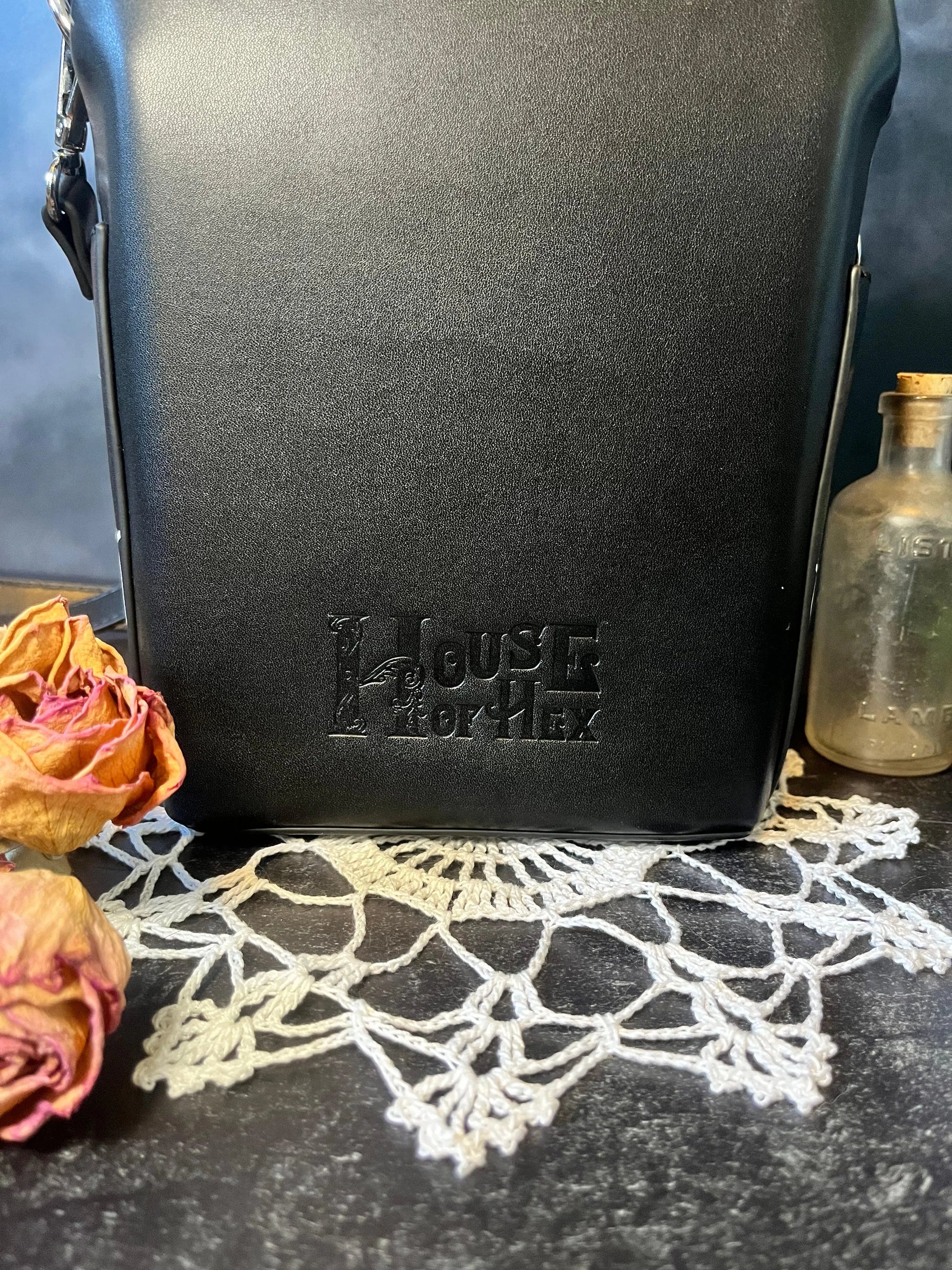 "House of Hex" logo on teh side of a black purse.