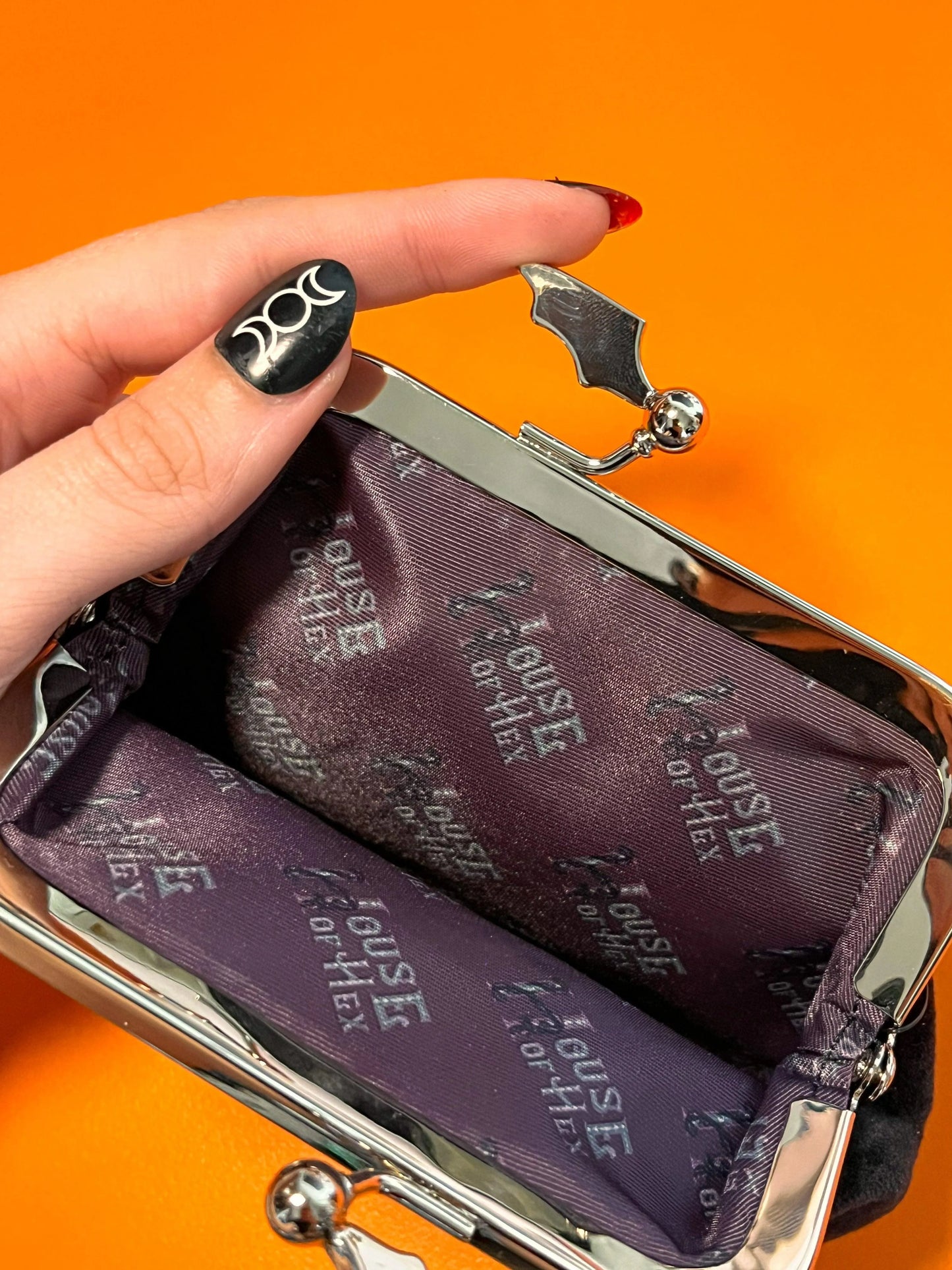 Black coin purse with a black interior that says "House of Hex".