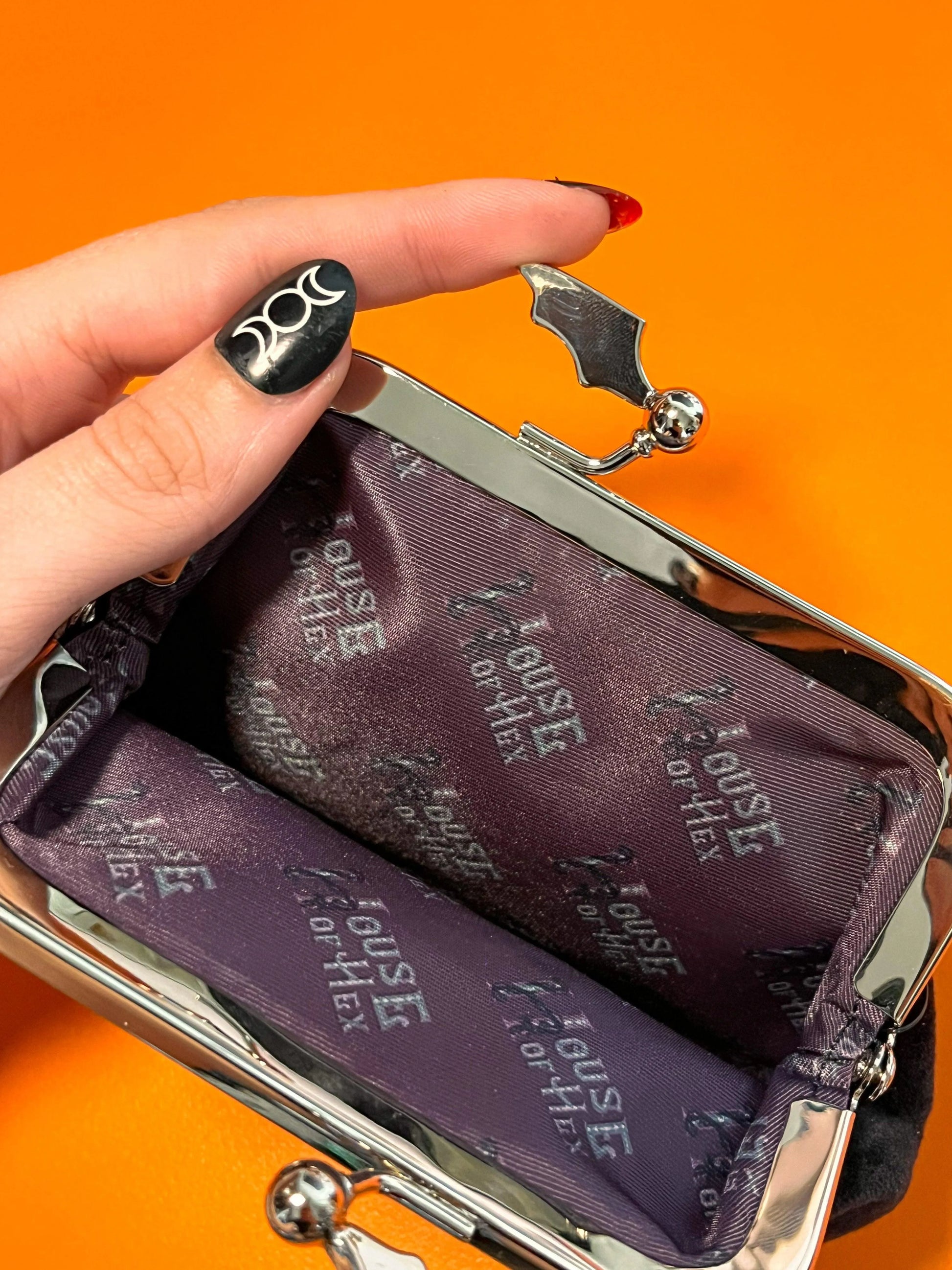 Black coin purse with a black interior that says "House of Hex".