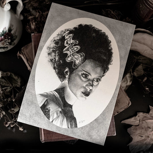 Black and white portrait drawing of the Bride of Frankenstein on a white oval surrounded by a grey rectangle.