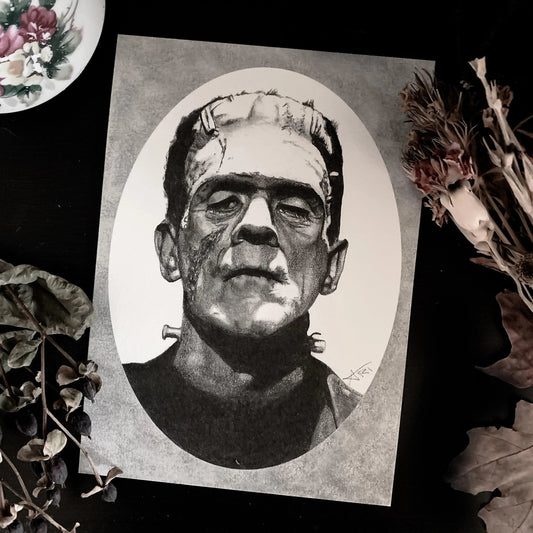 Black and white portrait drawing of Frankenstein's monster on a white oval surrounded by a grey rectangle.