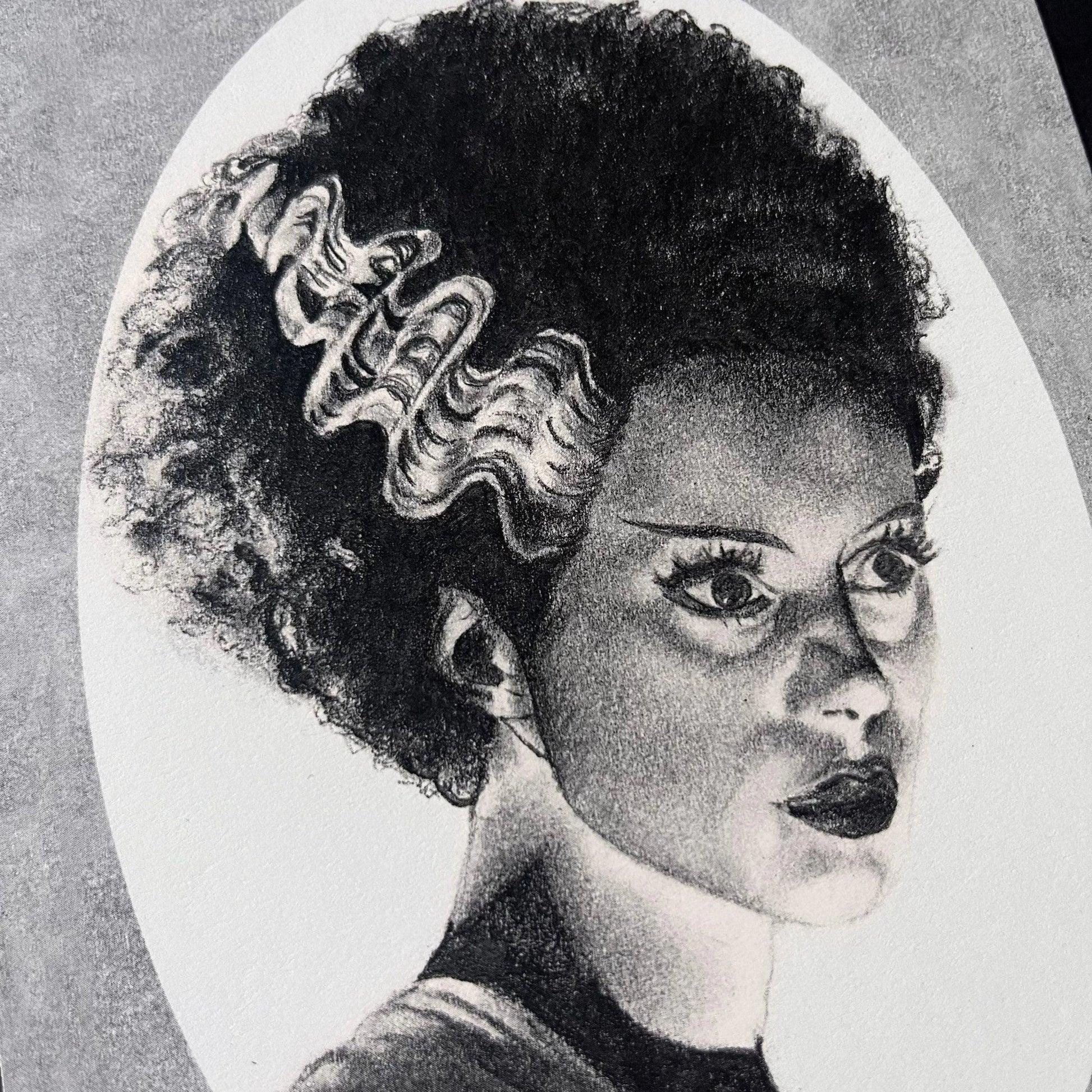Black and white portrait drawing of the Bride of Frankenstein on a white oval surrounded by a grey rectangle.