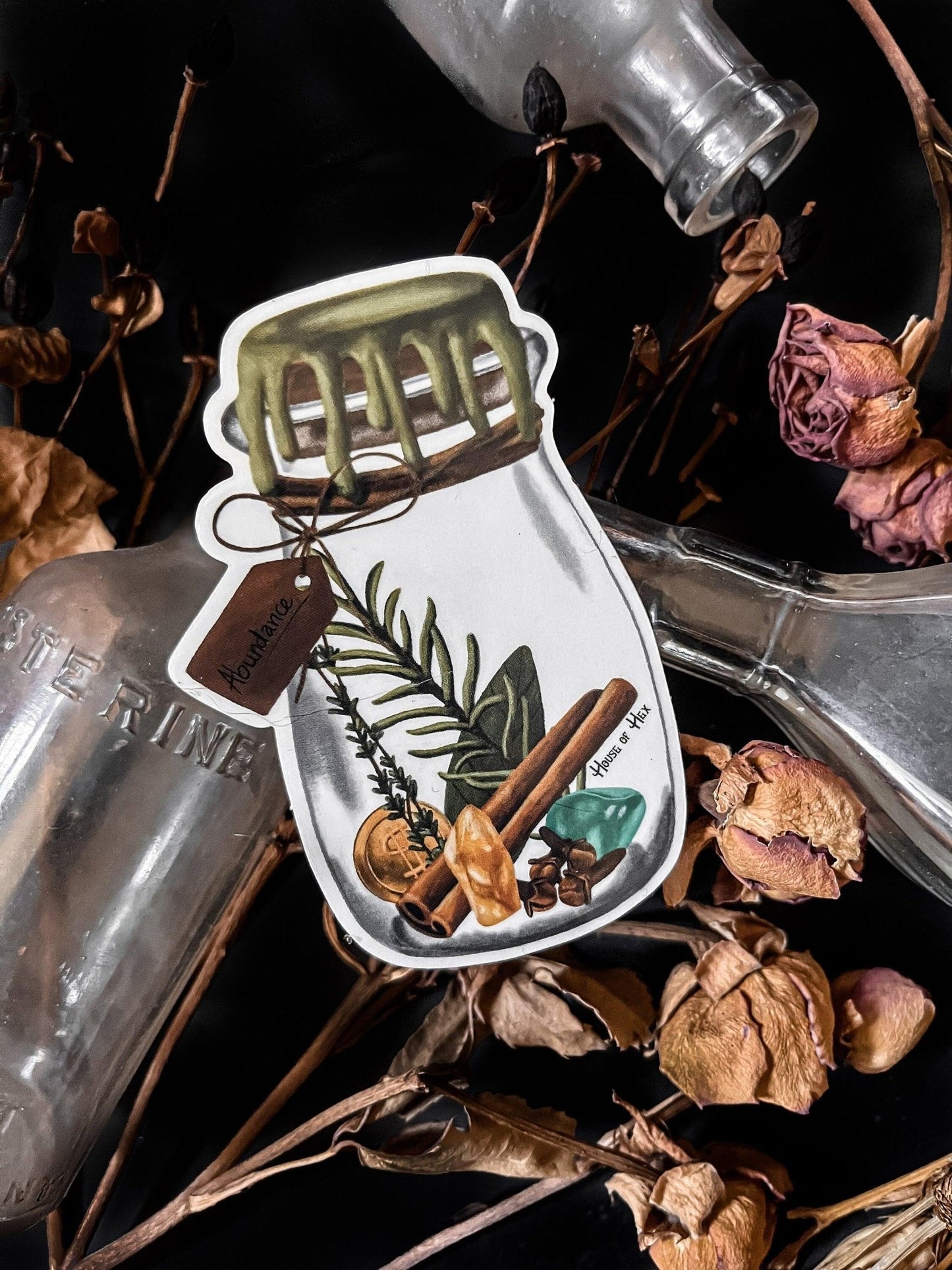 An artistic sticker illustrating a jar of herbs and spices in a white border with a tag that says "Abundance".