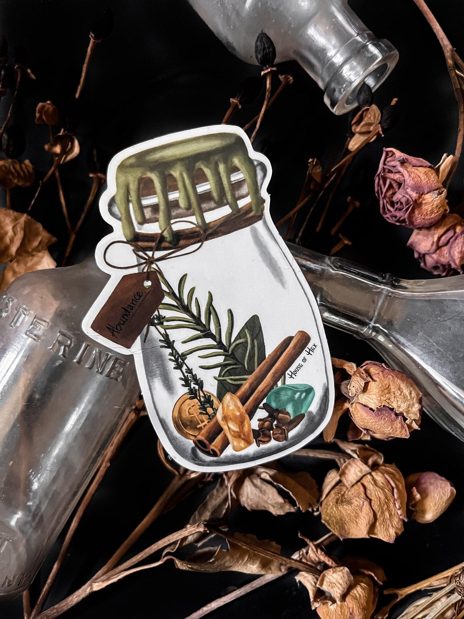 An artistic sticker illustrating a jar of herbs and spices in a white border with a tag that says "Abundance".