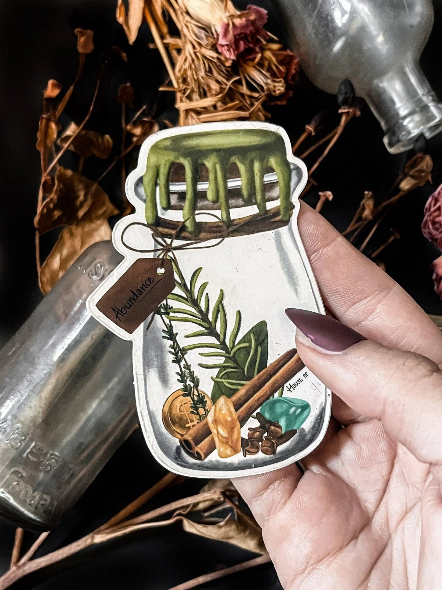 An artistic sticker illustrating a jar of herbs and spices in a white border with a tag that says "Abundance".