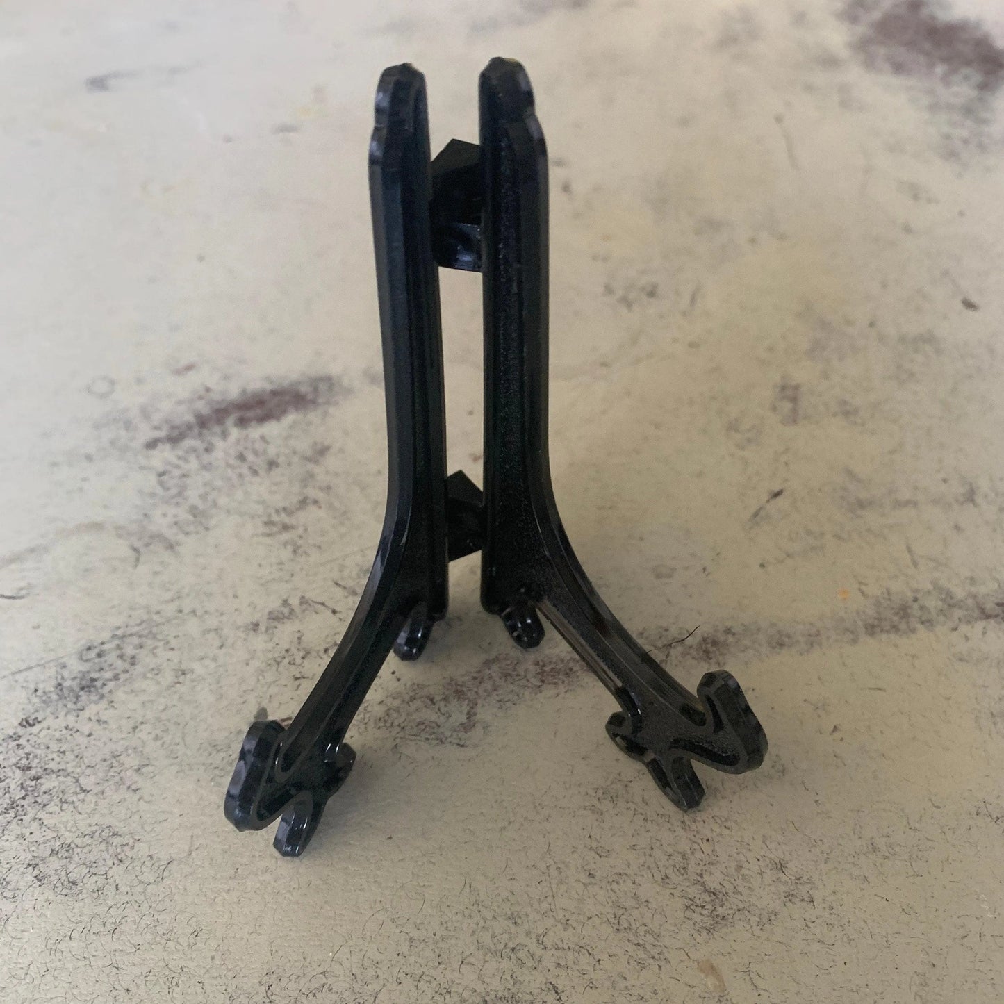 A decorative black plate stand open and upright.