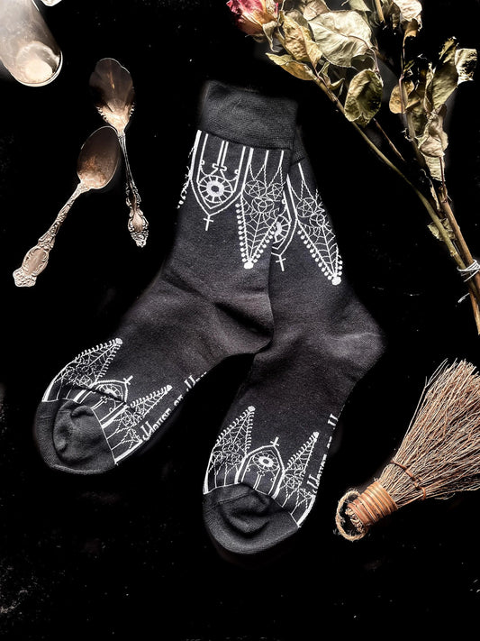 Black socks featuring gothic gables near the toe and ankles.
