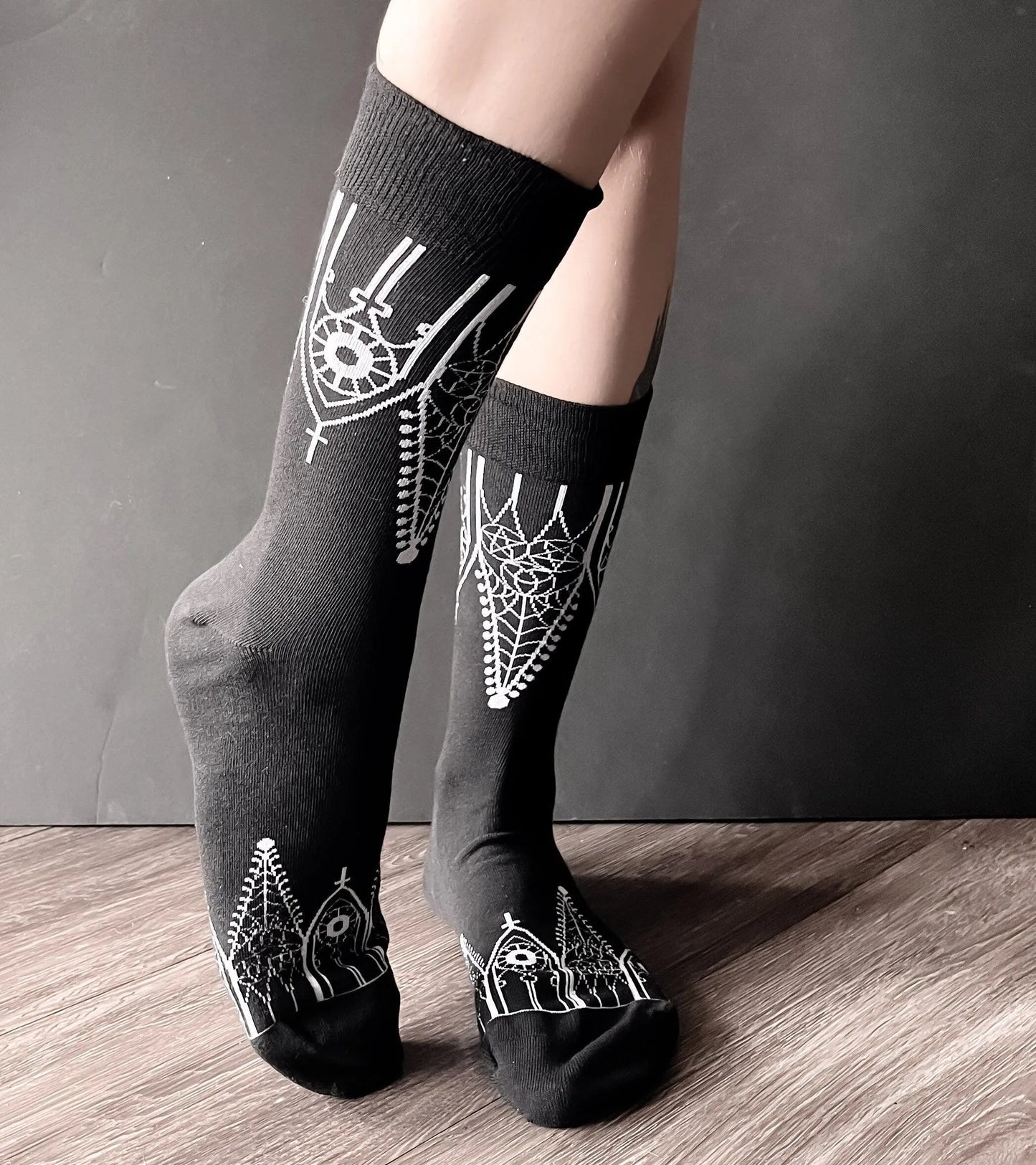 Black socks featuring gothic gables near the toe and ankles.