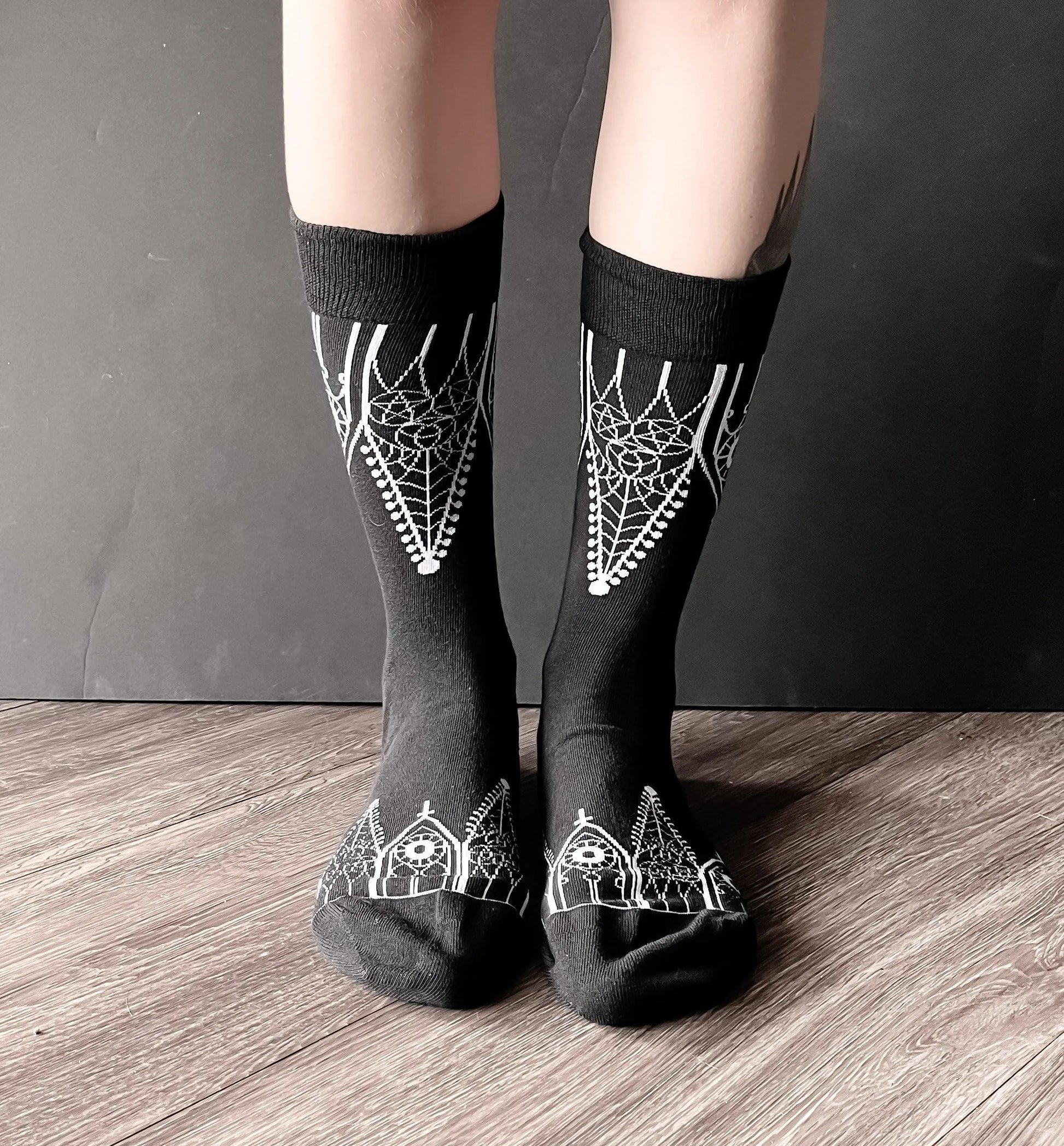 Black socks featuring gothic gables near the toe and ankles.