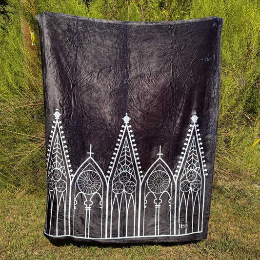 A black blanket featuring designs of Gothic gables in white.