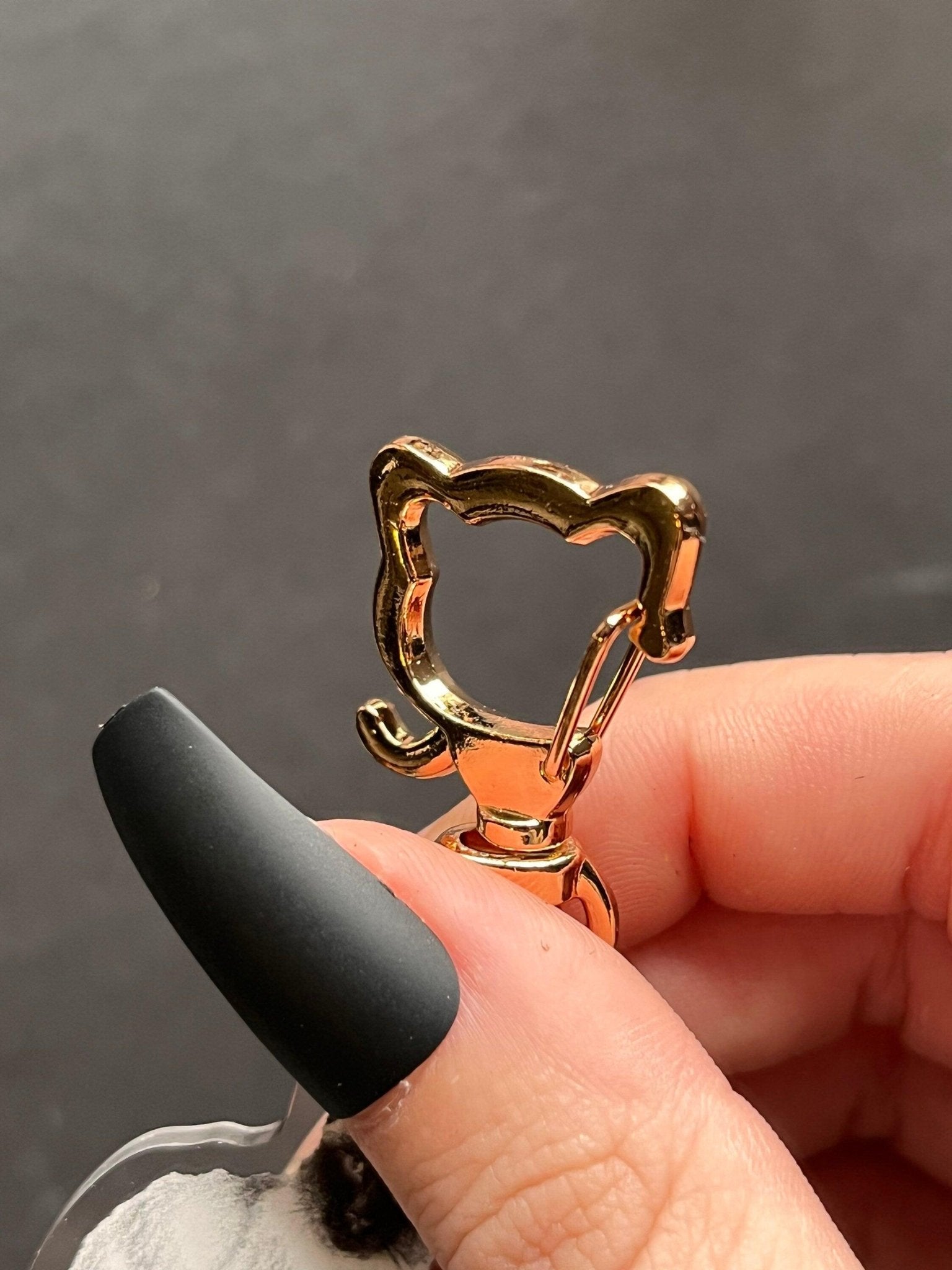 Golden cat-shaped clasp for a keychain.
