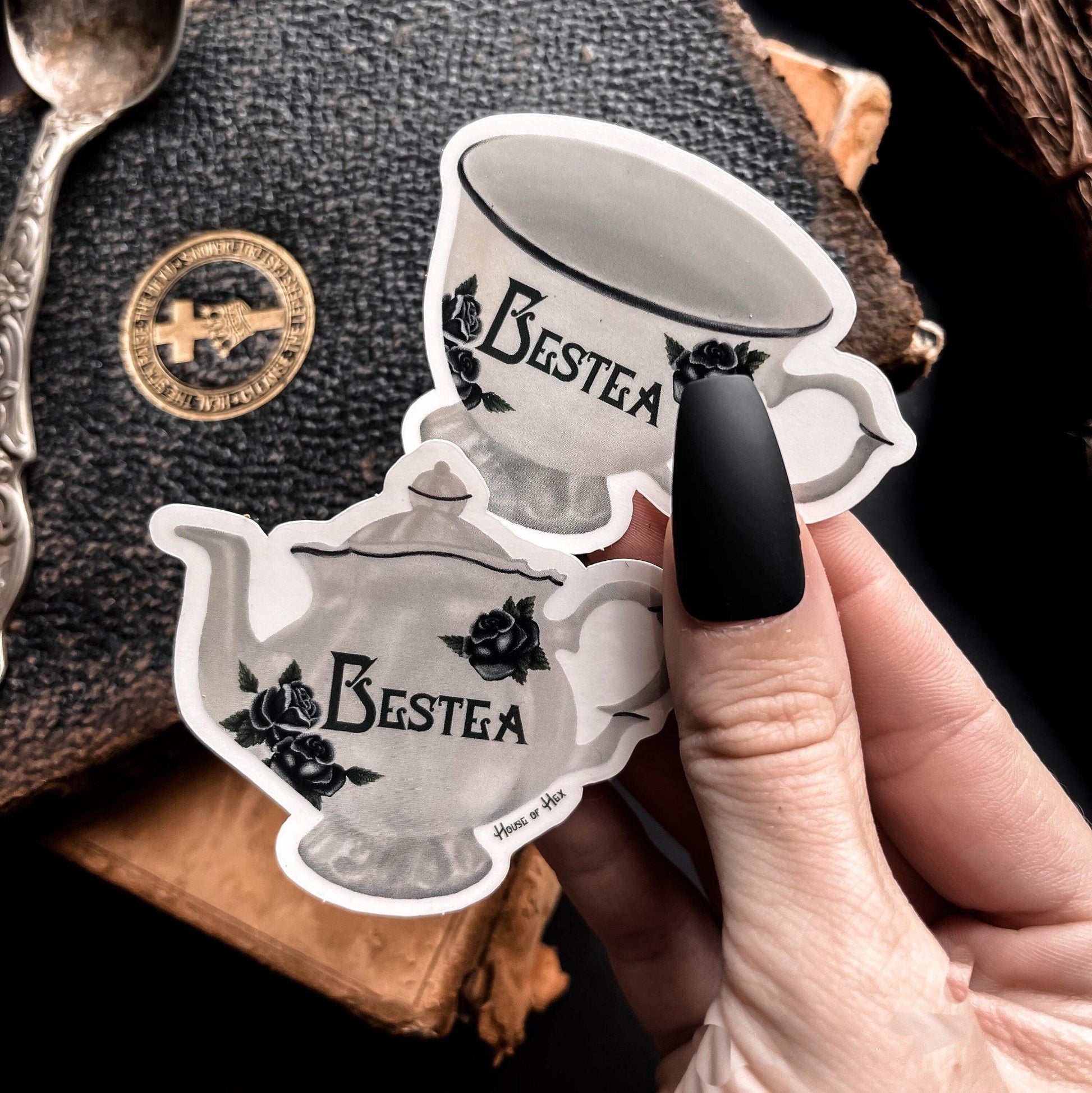 Two elegant white tea cup stickers with the word "Bestea" written in a gothic font. 