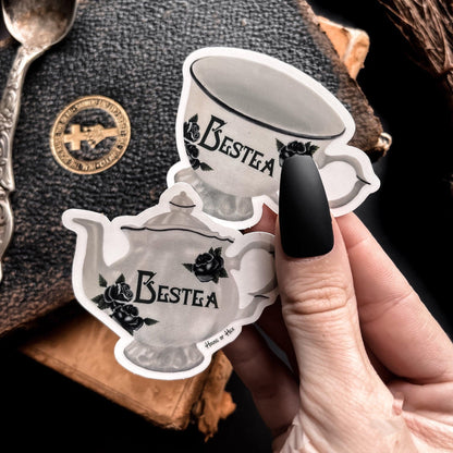 Two elegant white tea cup stickers with the word "Bestea" written in a gothic font. 