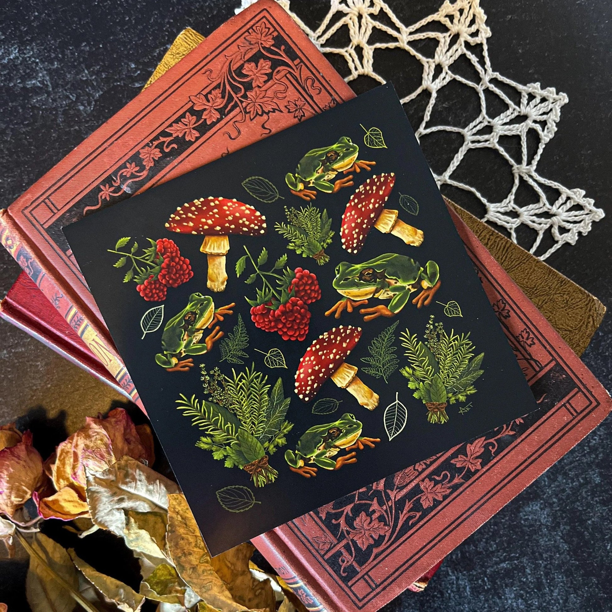 A decorative square print featuring a pattern of mushrooms, plants, and frogs on a black background.