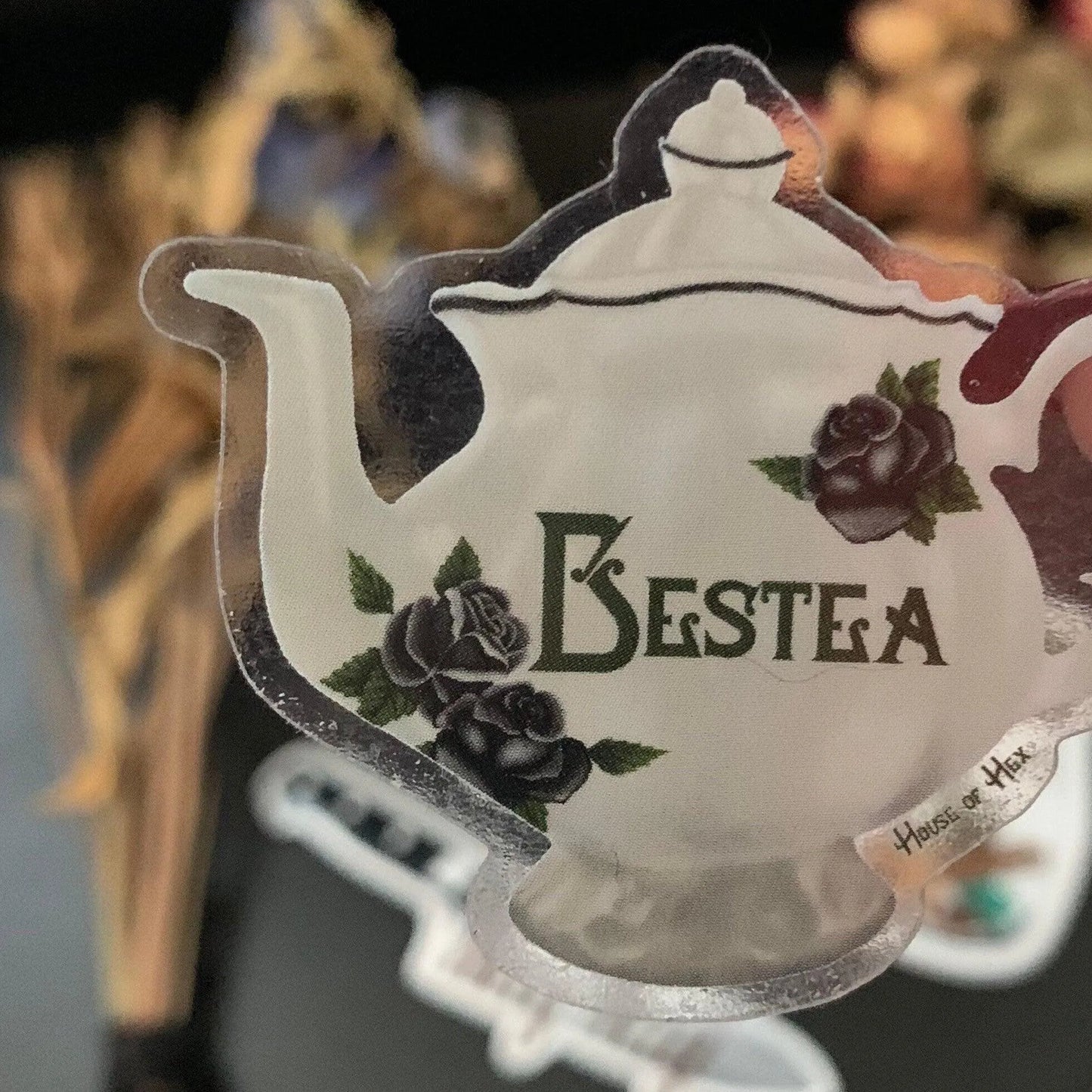 An elegant white tea cup sticker with the word "Bestea" written in a gothic font. 